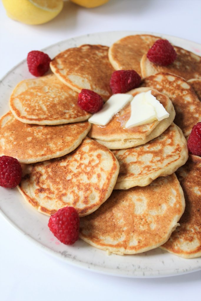 Healthy Lemon Ricotta Pancakes made with oat flour, naturally gluten free and refined sugar free. Topped with some raspberries and butter!