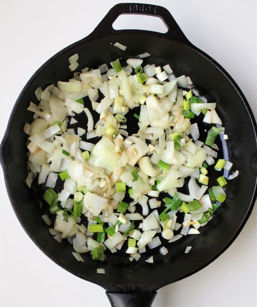 Skillet with sauteed onions, green onion, and garlic
