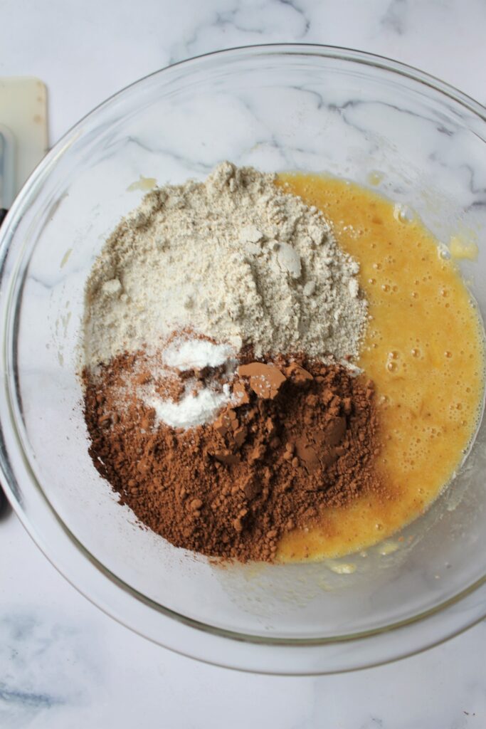 Chocolate Banana Bread dry ingredients on top of mixed wet ingredeints