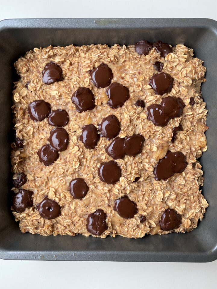 Close up of baking dish after baking vegan banana bread oat with melted chocolate chips on top
