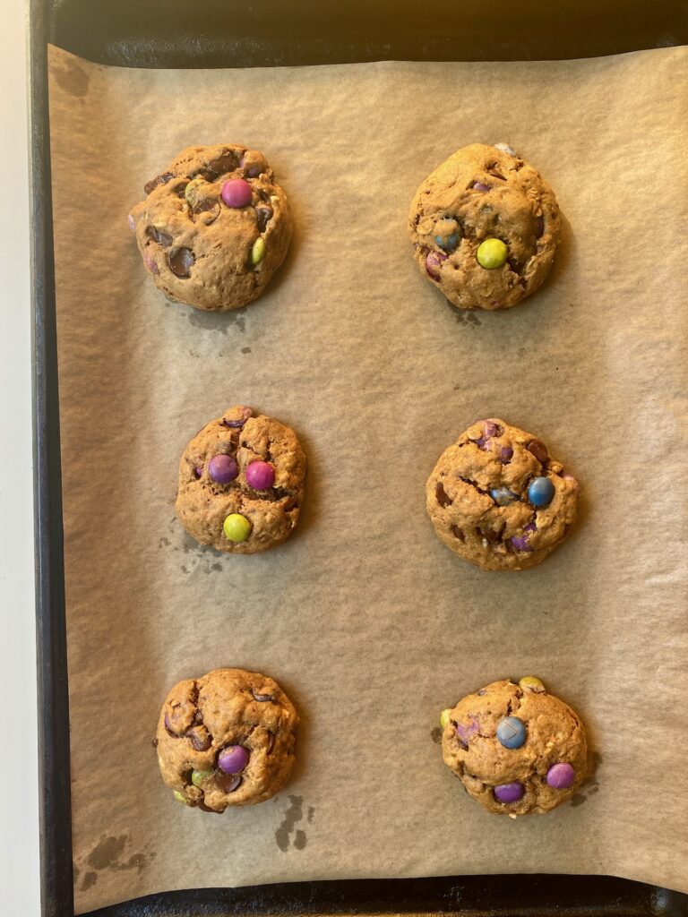monster cookies on sheet pan directly after coming out of the oven