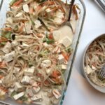 Pyrex of one pan of noodles and tofu in a curry sauce