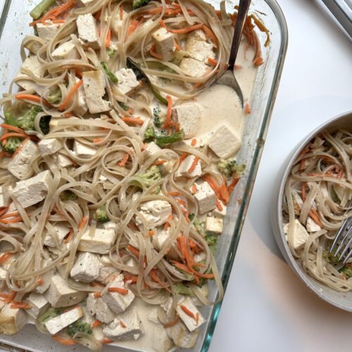 Pyrex of one pan of noodles and tofu in a curry sauce